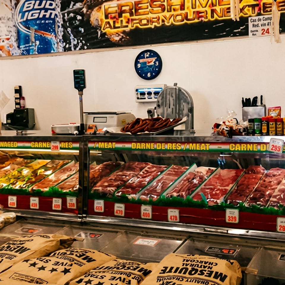 A butcher shop's refrigerated display cases showcase various fresh raw meats, spices, and charcoal for BBQ.